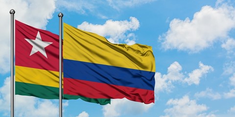 Togo and Colombia flag waving in the wind against white cloudy blue sky together. Diplomacy concept, international relations.