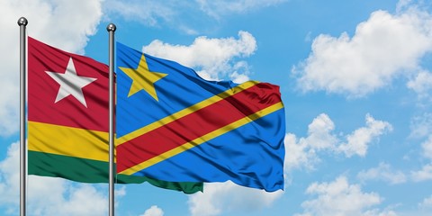 Togo and Congo flag waving in the wind against white cloudy blue sky together. Diplomacy concept, international relations.