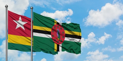 Togo and Dominica flag waving in the wind against white cloudy blue sky together. Diplomacy concept, international relations.