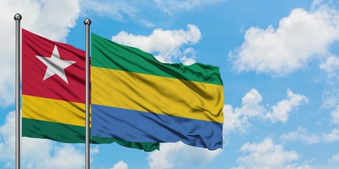 Togo and Gabon flag waving in the wind against white cloudy blue sky together. Diplomacy concept, international relations.