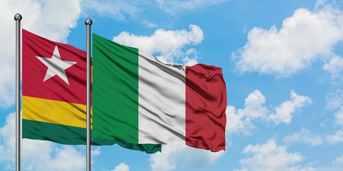 Togo and Italy flag waving in the wind against white cloudy blue sky together. Diplomacy concept, international relations.