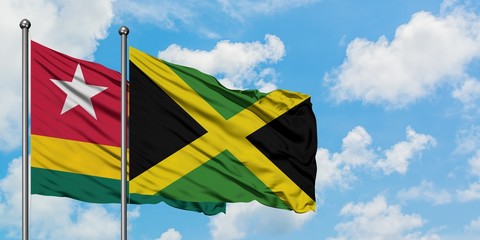 Togo and Jamaica flag waving in the wind against white cloudy blue sky together. Diplomacy concept, international relations.