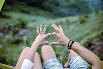 Hands couple lover showing heart shape in tent together,Enjoying camping concept