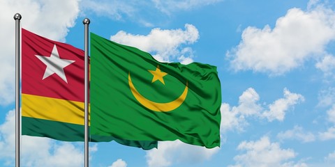 Togo and Mauritania flag waving in the wind against white cloudy blue sky together. Diplomacy concept, international relations.