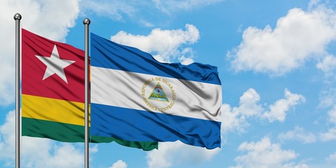 Togo and Nicaragua flag waving in the wind against white cloudy blue sky together. Diplomacy concept, international relations.