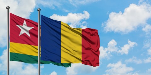 Togo and Romania flag waving in the wind against white cloudy blue sky together. Diplomacy concept,...