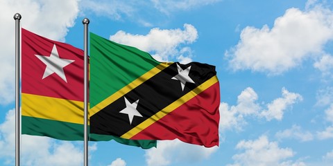 Togo and Saint Kitts And Nevis flag waving in the wind against white cloudy blue sky together. Diplomacy concept, international relations.