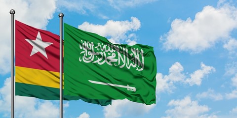 Togo and Saudi Arabia flag waving in the wind against white cloudy blue sky together. Diplomacy concept, international relations.