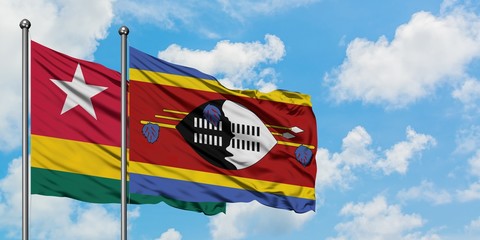 Togo and Swaziland flag waving in the wind against white cloudy blue sky together. Diplomacy concept, international relations.