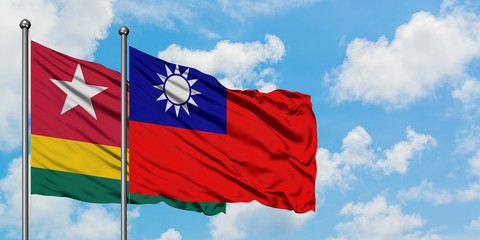 Fototapeta na wymiar Togo and Taiwan flag waving in the wind against white cloudy blue sky together. Diplomacy concept, international relations.