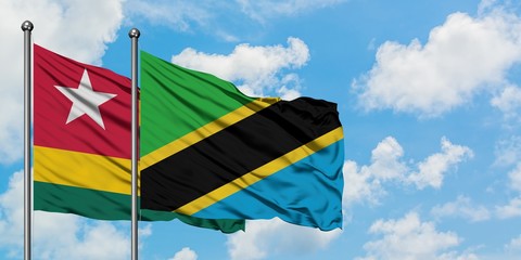 Togo and Tanzania flag waving in the wind against white cloudy blue sky together. Diplomacy concept, international relations.