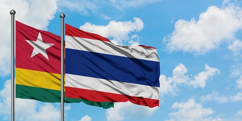 Togo and Thailand flag waving in the wind against white cloudy blue sky together. Diplomacy concept, international relations.