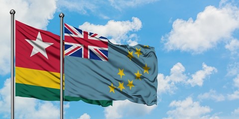 Togo and Tuvalu flag waving in the wind against white cloudy blue sky together. Diplomacy concept, international relations.