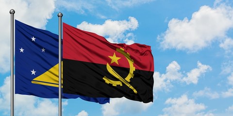 Tokelau and Angola flag waving in the wind against white cloudy blue sky together. Diplomacy concept, international relations.