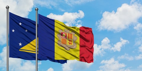Tokelau and Andorra flag waving in the wind against white cloudy blue sky together. Diplomacy concept, international relations.