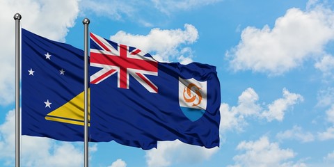 Tokelau and Anguilla flag waving in the wind against white cloudy blue sky together. Diplomacy concept, international relations.