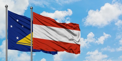 Tokelau and Austria flag waving in the wind against white cloudy blue sky together. Diplomacy concept, international relations.