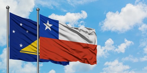 Tokelau and Chile flag waving in the wind against white cloudy blue sky together. Diplomacy concept, international relations.