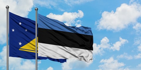 Tokelau and Estonia flag waving in the wind against white cloudy blue sky together. Diplomacy concept, international relations.