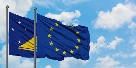 Tokelau and European Union flag waving in the wind against white cloudy blue sky together. Diplomacy concept, international relations.