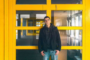 Fototapeta na wymiar portrait of a casual young man in front of yellow windows
