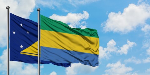Tokelau and Gabon flag waving in the wind against white cloudy blue sky together. Diplomacy concept, international relations.
