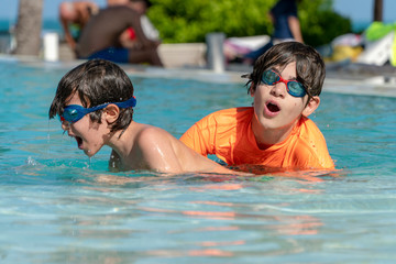 brothers having fun at the pool on exotic island