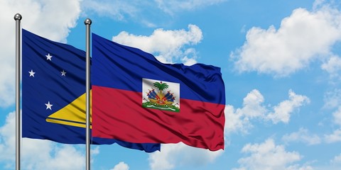 Tokelau and Haiti flag waving in the wind against white cloudy blue sky together. Diplomacy concept, international relations.