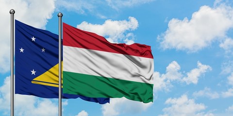 Tokelau and Hungary flag waving in the wind against white cloudy blue sky together. Diplomacy concept, international relations.