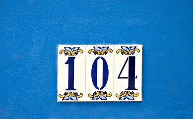 Number 104, one hundred and four, decorative digits on a blue background.