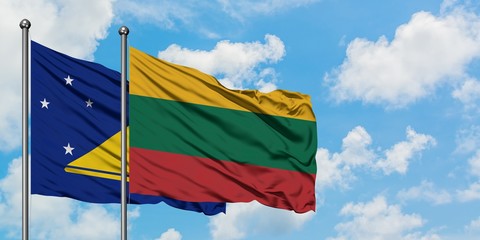 Tokelau and Lithuania flag waving in the wind against white cloudy blue sky together. Diplomacy concept, international relations.