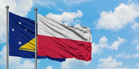 Tokelau and Poland flag waving in the wind against white cloudy blue sky together. Diplomacy concept, international relations.