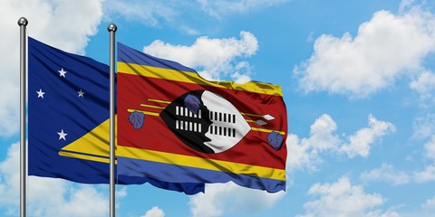 Tokelau and Swaziland flag waving in the wind against white cloudy blue sky together. Diplomacy concept, international relations.