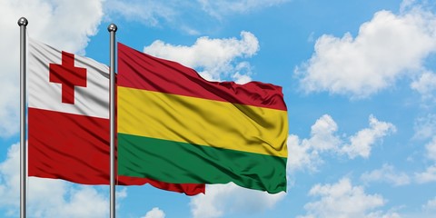 Tonga and Bolivia flag waving in the wind against white cloudy blue sky together. Diplomacy concept, international relations.
