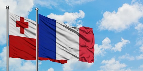 Tonga and France flag waving in the wind against white cloudy blue sky together. Diplomacy concept, international relations.