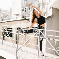 Beautiful sport fitness girl in sportswear doing fitness exercise in the street ,outdoor sports. Urban style.