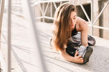 Beautiful sport fitness girl in sportswear doing fitness exercise in the street ,outdoor sports. Urban style.