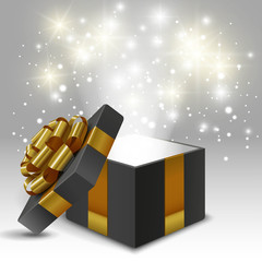 Opened gift box with gold bow and lights