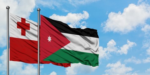 Tonga and Jordan flag waving in the wind against white cloudy blue sky together. Diplomacy concept, international relations.