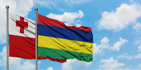 Tonga and Mauritius flag waving in the wind against white cloudy blue sky together. Diplomacy concept, international relations.