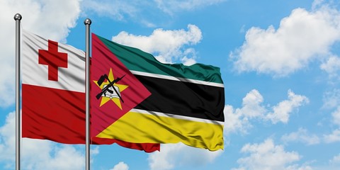 Tonga and Mozambique flag waving in the wind against white cloudy blue sky together. Diplomacy concept, international relations.