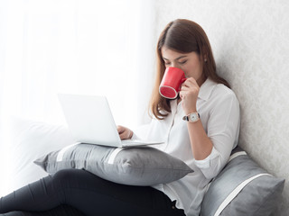 Asian business girl working and drinking coffee in living room