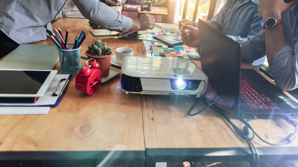 Group of Asian designers brainstorming working together with colleagues and color swatches in co-working workplace.