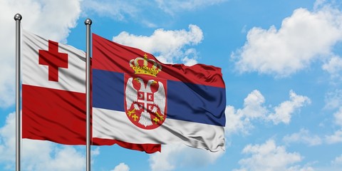 Tonga and Serbia flag waving in the wind against white cloudy blue sky together. Diplomacy concept, international relations.