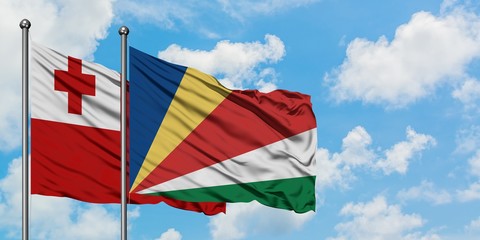 Tonga and Seychelles flag waving in the wind against white cloudy blue sky together. Diplomacy concept, international relations.