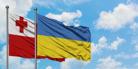 Tonga and Ukraine flag waving in the wind against white cloudy blue sky together. Diplomacy concept, international relations.