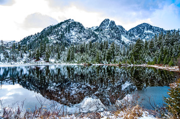 Mountains reflected in the lake still water. A ridge of North Cascades of Washington