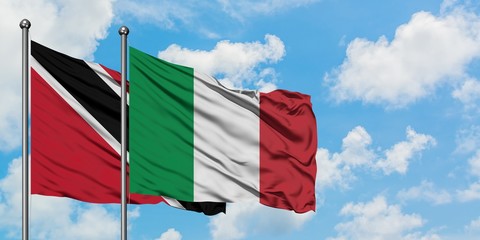 Trinidad And Tobago and Italy flag waving in the wind against white cloudy blue sky together. Diplomacy concept, international relations.