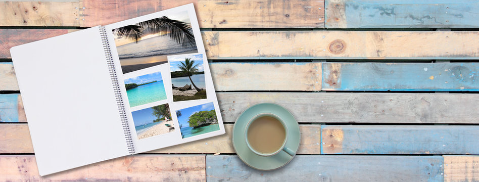 Banner Photobook Album with Travel Photo on Wooden Floor Table with Coffee or Tea in Cup