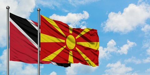 Trinidad And Tobago and Macedonia flag waving in the wind against white cloudy blue sky together. Diplomacy concept, international relations.